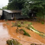 Floodwaters covering streets and homes in Oahu, Hawaii during severe flash flooding and evacuation efforts.